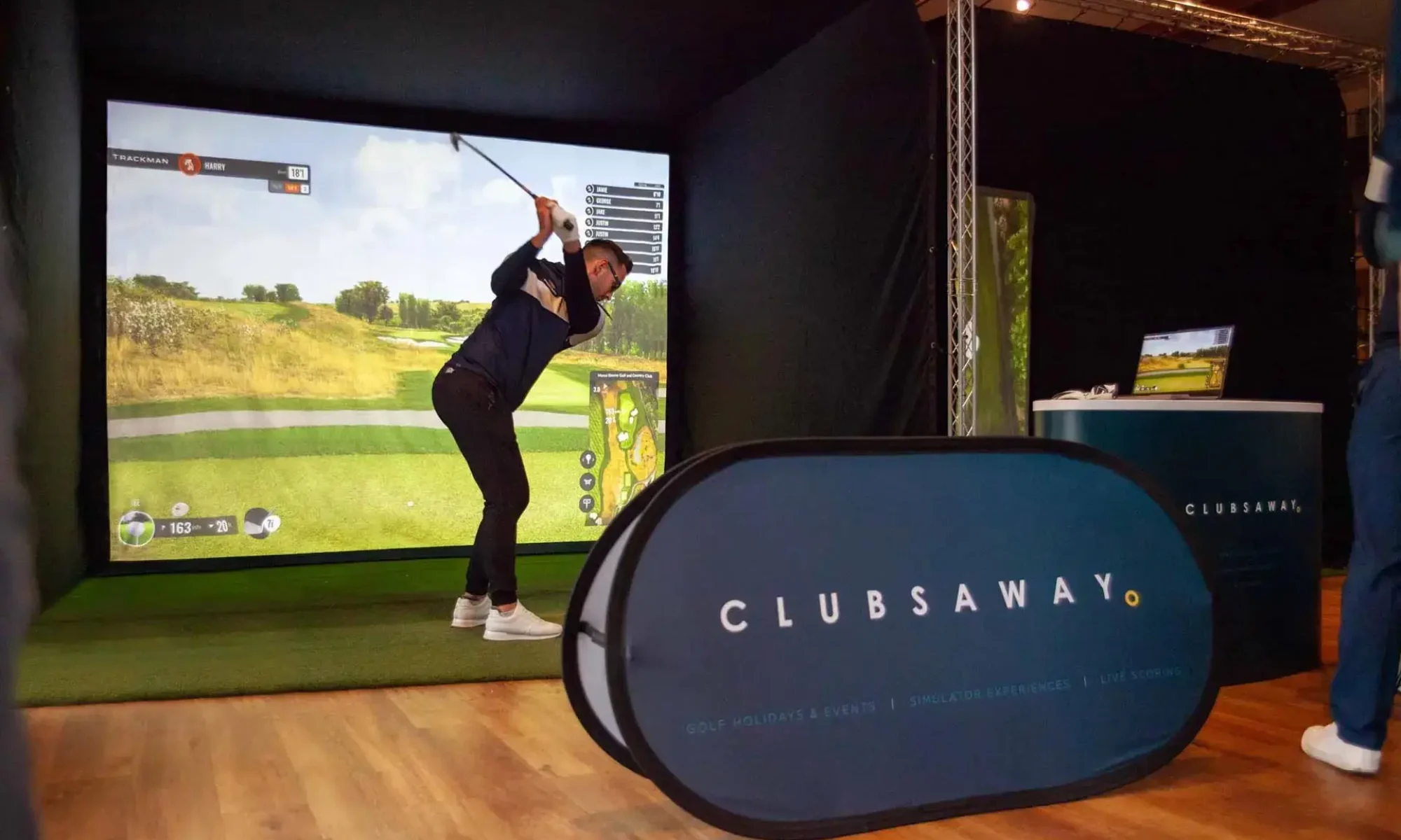Guests playing on two mobile Trackman golf simulators at a charity golf day.